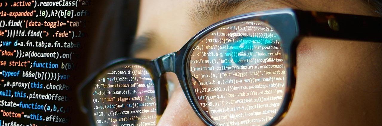 Imagen ilustrativa para el artículo. Persona con gafas visualizando una pantalla de computadora que dispone código en JavaScript